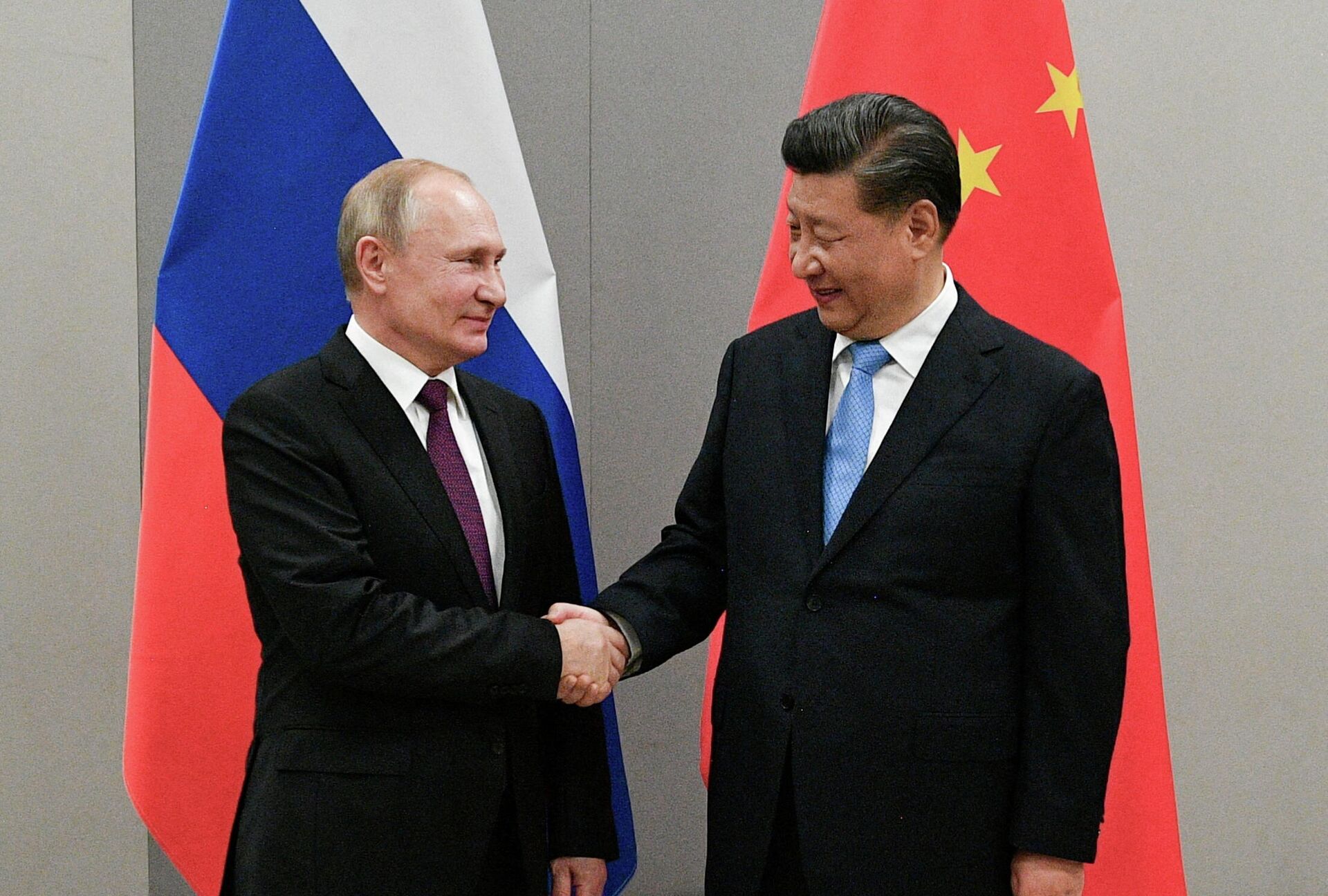 O presidente russo, Vladimir Putin, aperta a mão do presidente chinês, Xi Jinping, durante reunião paralela a uma cúpula do BRICS, em Brasília, no Brasil, em 13 de novembro de 2019 - Sputnik Brasil, 1920, 07.01.2022