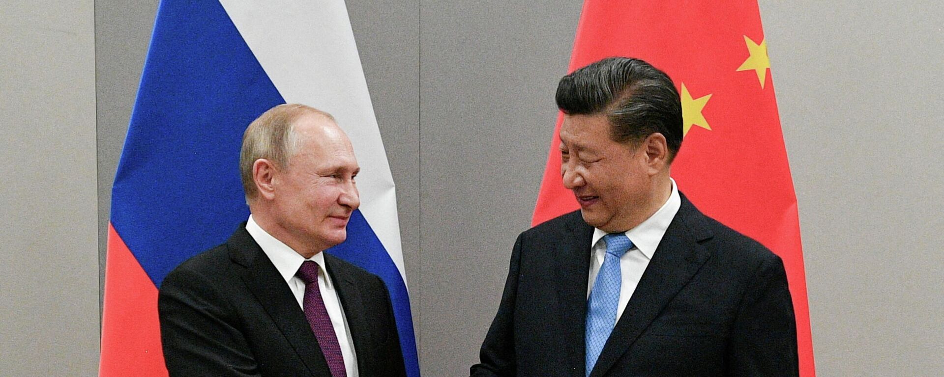 O presidente russo, Vladimir Putin, aperta a mão do presidente chinês, Xi Jinping, durante reunião paralela a uma cúpula do BRICS, em Brasília, no Brasil, em 13 de novembro de 2019 - Sputnik Brasil, 1920, 30.12.2021