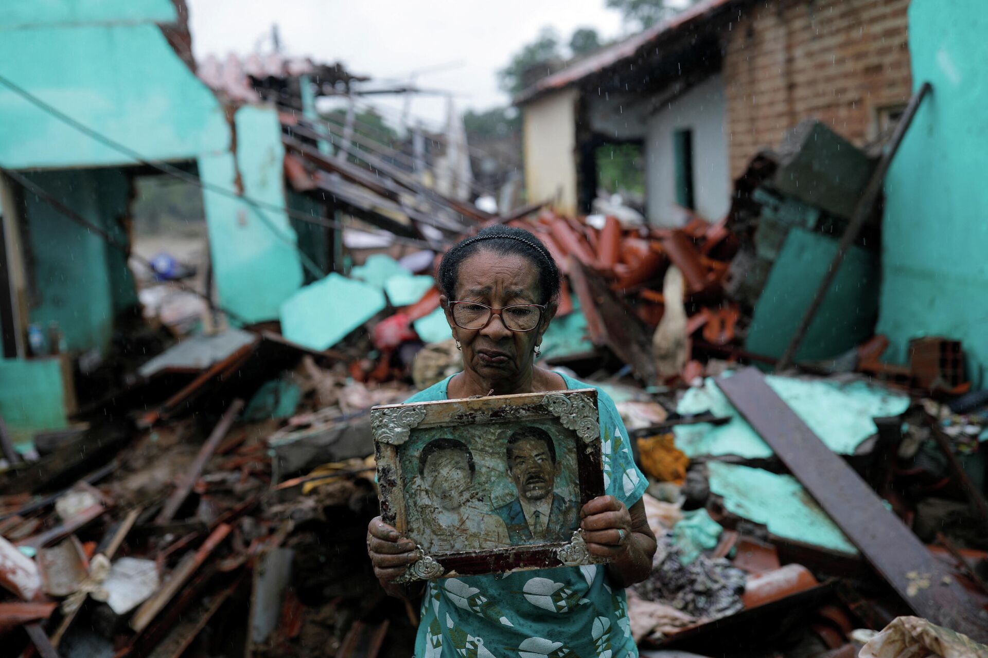 Vitória Rocha, de 81 anos, mostra retrato de seus pais em meio aos escombros de sua casa destruída em decorrência das enchentes. Itambé, Bahia, 28 de dezembro de 2021 - Sputnik Brasil, 1920, 30.12.2021