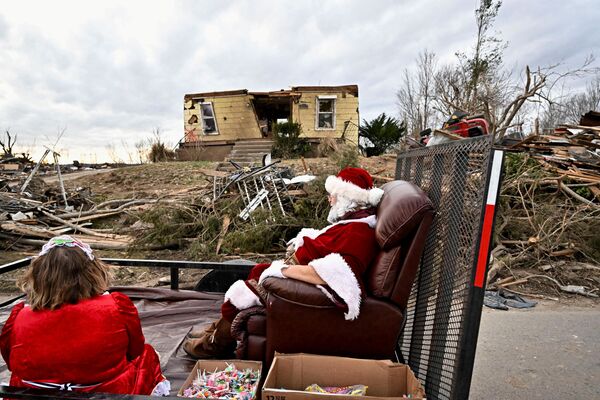 Steely Vanlue em traje de Papai Noel, sentado em frente de uma casa destruída em Dawson Springs, EUA. - Sputnik Brasil