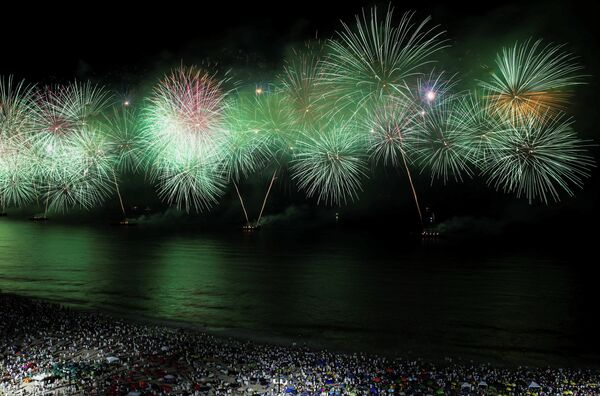 Pessoas assistem aos fogos de artifício em Copacabana durante as celebrações do Ano Novo no Rio 
 - Sputnik Brasil