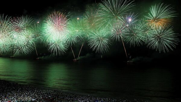 Pessoas assistem aos fogos de artifício em Copacabana durante as celebrações do Ano Novo no Rio 
 - Sputnik Brasil