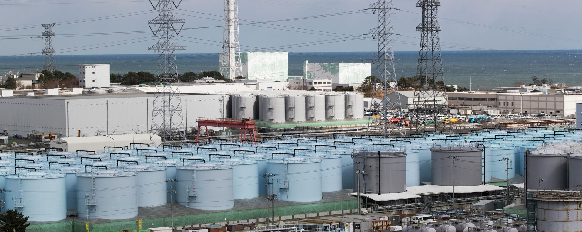 Reator nuclear Nº 5, no centro-esquerda, e reator 6 por trás de tanques com água tratada, mas ainda radioativa, na usina nuclear de Fukushima Daiichi, na cidade de Okuma, prefeitura de Fukushima, nordeste do Japão - Sputnik Brasil, 1920, 24.08.2022