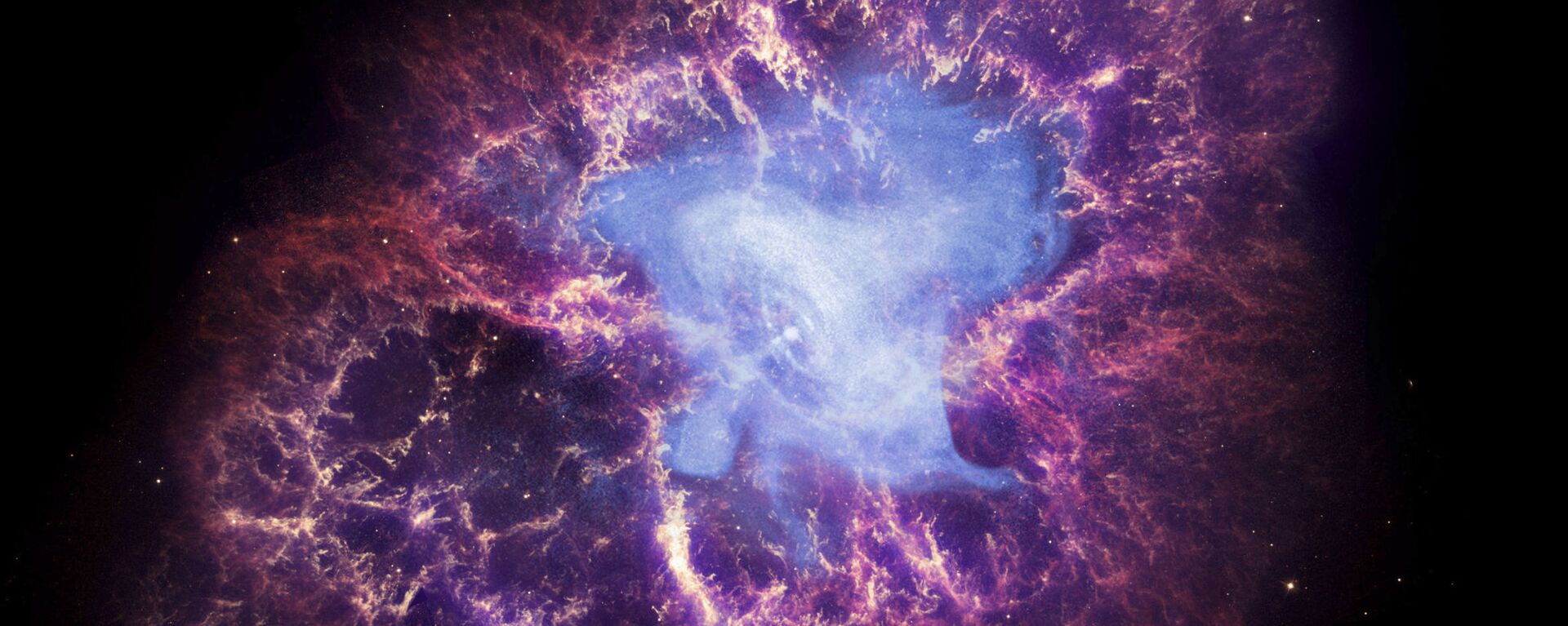 Esta imagem composta disponibilizada pela NASA mostra uma estrela de nêutrons, no centro, deixada para trás pela explosão da morte da estrela original na constelação de Touro, observada na Terra como a supernova de 1054 DC. Esta imagem usa dados de três observatórios da NASA: a imagem de raios-X do Chandra é exibida em azul, a imagem ótica do Telescópio Espacial Hubble está em vermelho e amarelo, e a imagem infravermelha do Telescópio Espacial Spitzer está em roxo. Depois de quase duas décadas na órbita da Terra, examinando o universo com olhos infravermelhos, os controladores terrestres planejam colocar o vacilante Telescópio Espacial Spitzer em hibernação permanente na quinta-feira, 29 de janeiro de 2020 - Sputnik Brasil, 1920, 31.08.2023