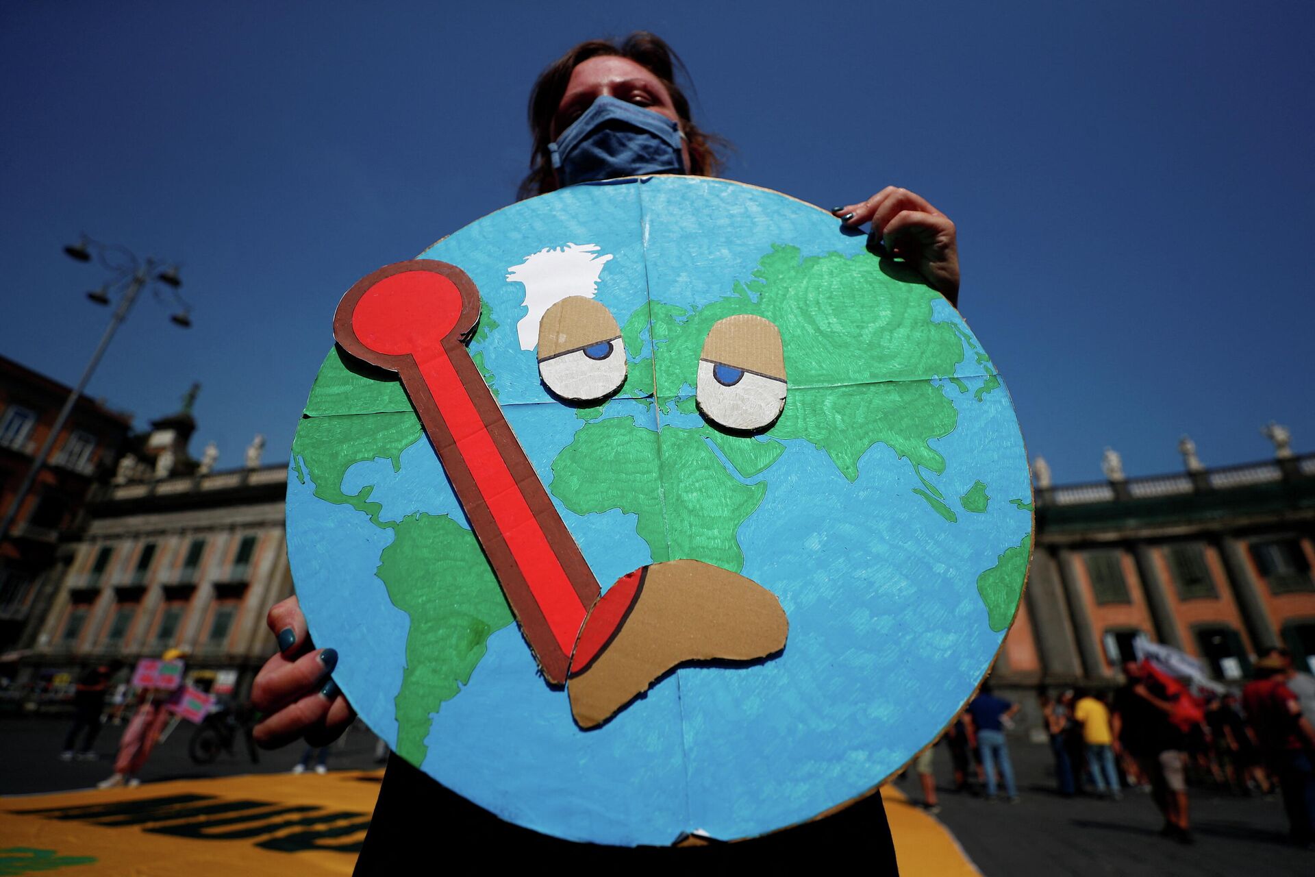 Pessoa segura cartaz mostrando a Terra doente enquanto ativistas do clima encenam protesto exigindo mais ações, durante a cúpula do G20, Itália, 22 de julho de 2021 - Sputnik Brasil, 1920, 03.01.2022