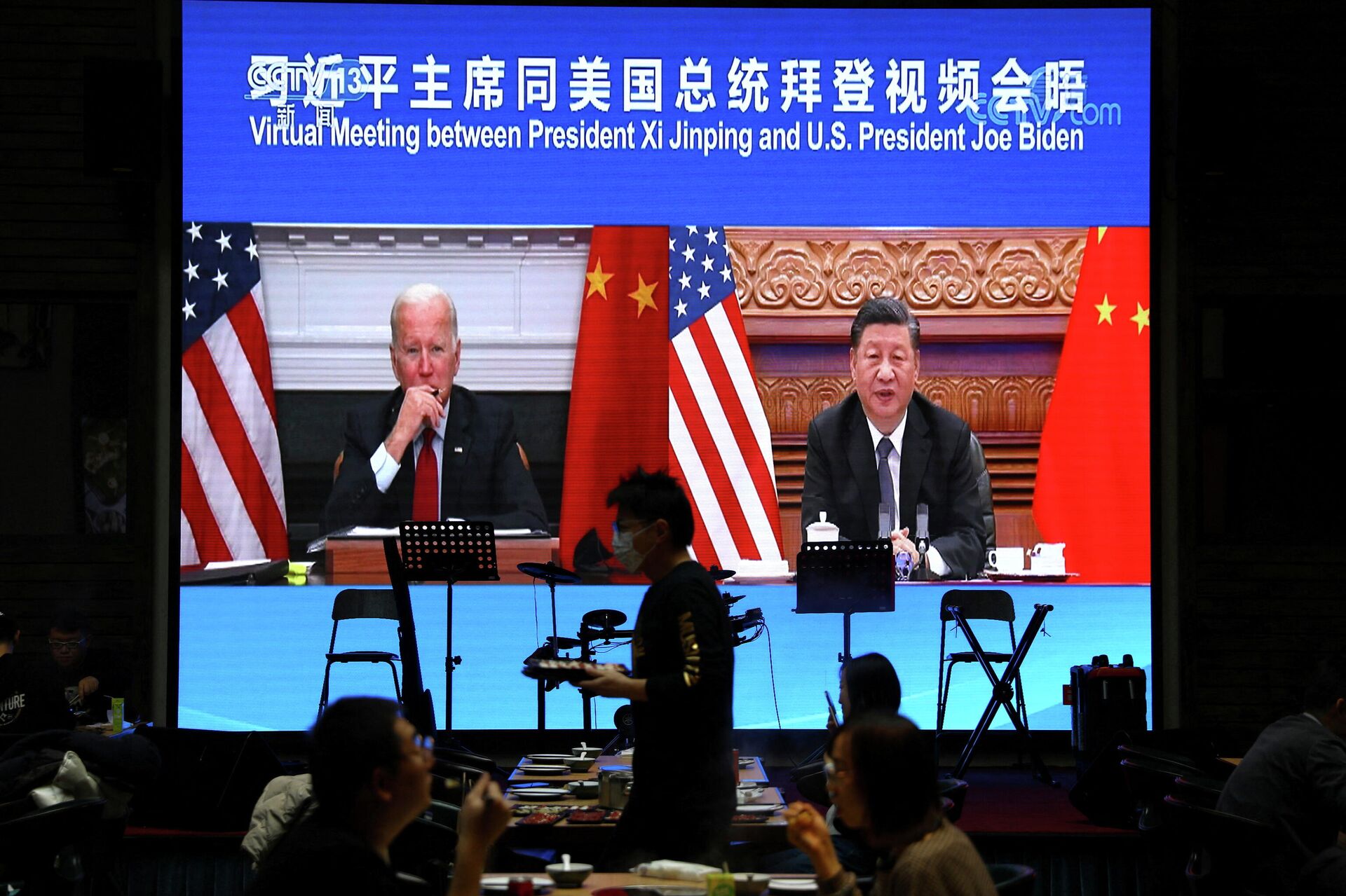 Uma tela mostra o presidente chinês Xi Jinping participando de uma reunião virtual com o presidente dos EUA Joe Biden via link de vídeo, em um restaurante em Pequim, China, em 16 de novembro de 2021 - Sputnik Brasil, 1920, 04.01.2022