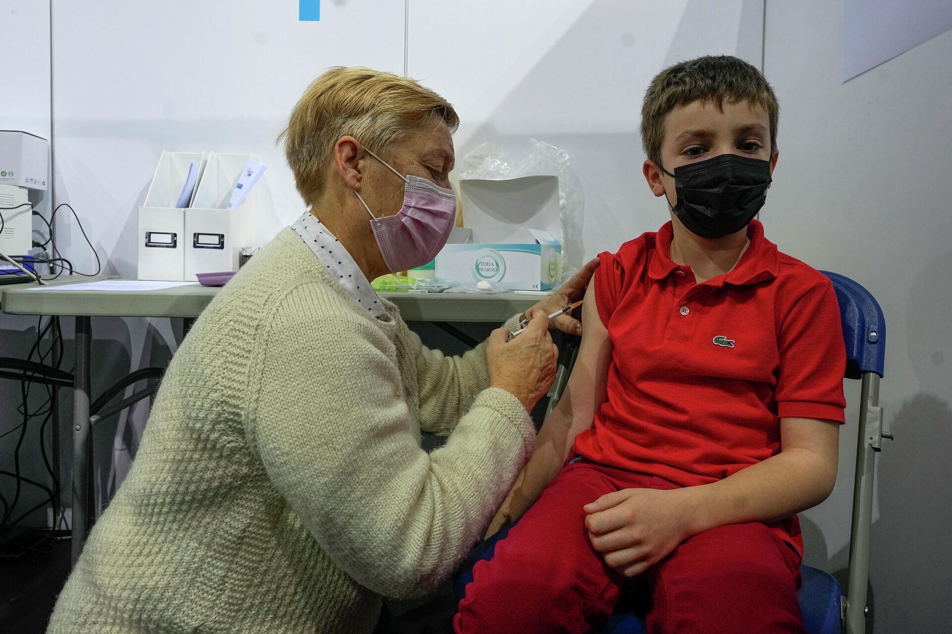 Uma profissional da saúde administra uma dose da vacina Pfizer contra a COVID-19 em uma criança de oito anos, em Saint-Quentin-en-Yvelines, a oeste de Paris, na França, no dia 22 de dezembro de 2021 - Sputnik Brasil, 1920, 18.01.2022