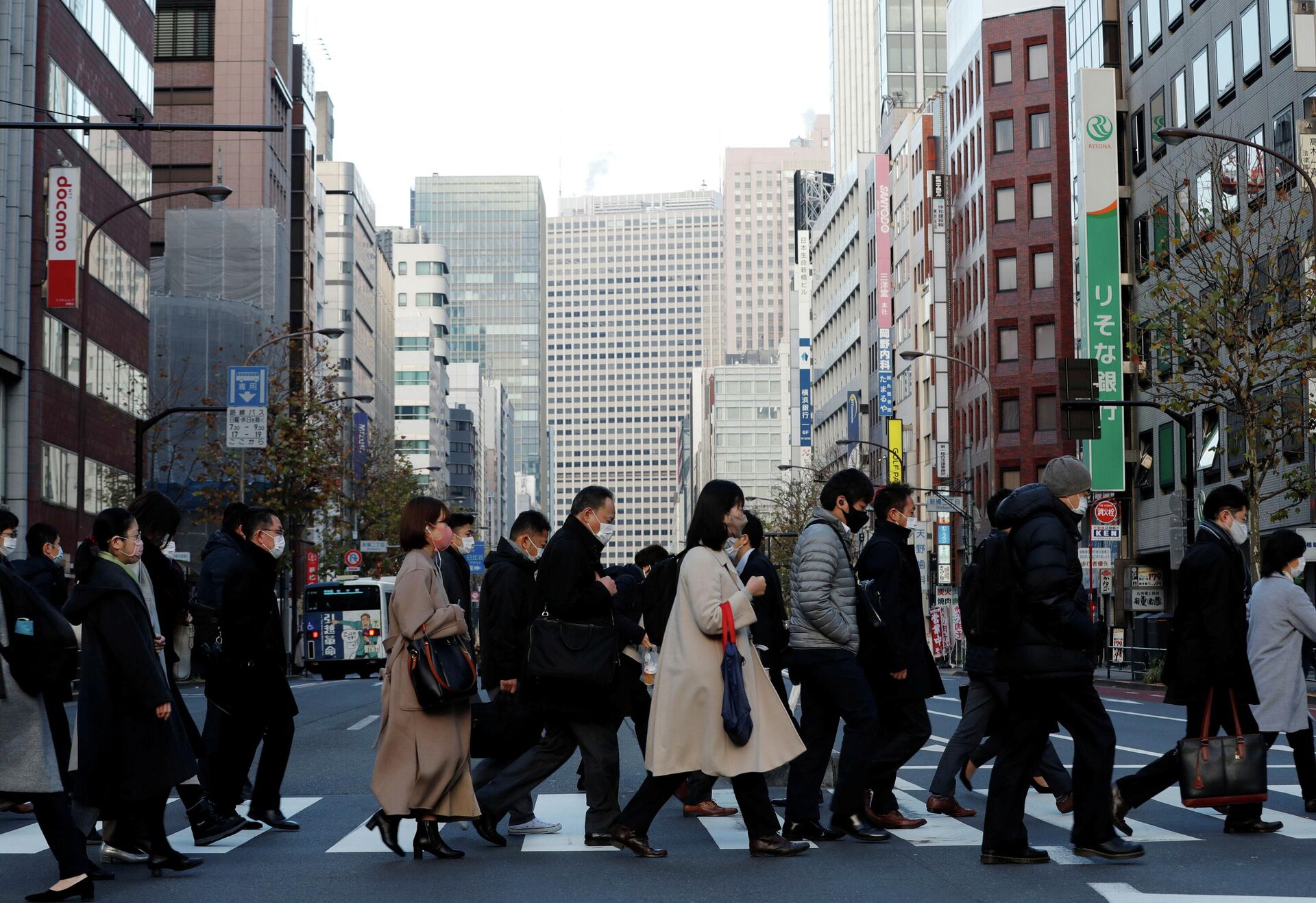 Pedestres usando máscaras protetoras, após o surto da doença coronavírus (COVID-19), fazem seu caminho durante o horário de deslocamento em um distrito comercial em Tóquio, Japão, 7 de janeiro de 2021 - Sputnik Brasil, 1920, 04.01.2022