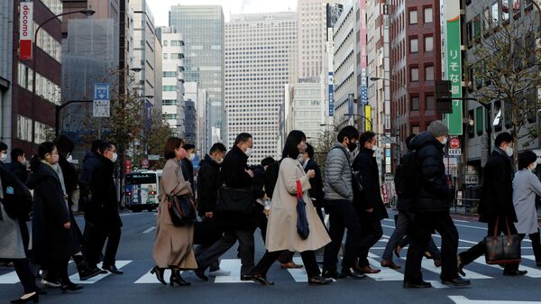 Pedestres usando máscaras protetoras, após o surto da doença coronavírus (COVID-19), fazem seu caminho durante o horário de deslocamento em um distrito comercial em Tóquio, Japão, 7 de janeiro de 2021 - Sputnik Brasil