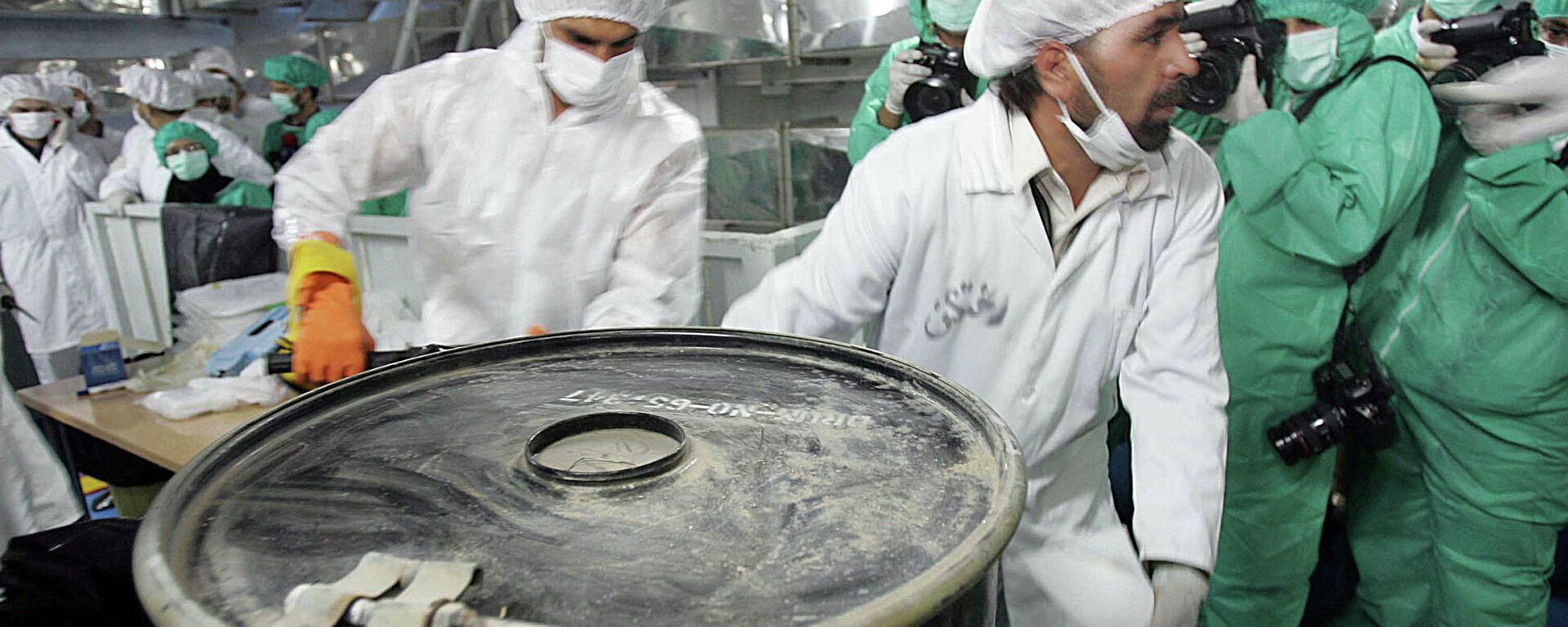 Dois técnicos carregam uma caixa contendo concentrado de minério de urânio, conhecido como yellowcake, na Instalação de Conversão de Urânio do Irã, nos arredores da cidade de Isfahan, 410 quilômetros ao sul da capital Teerã, em 8 de agosto de 2005 - Sputnik Brasil, 1920, 05.01.2022