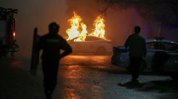Carro policial queimando durante protestos contra a subida do preço de gás de petróleo liquefeito pelas autoridades cazaques, em Almaty, Cazaquistão, 5 de janeiro de 2022 - Sputnik Brasil