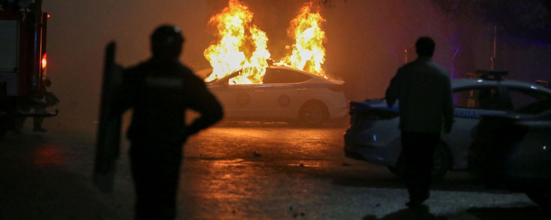 Carro policial queimando durante protestos contra a subida do preço de gás de petróleo liquefeito pelas autoridades cazaques, em Almaty, Cazaquistão, 5 de janeiro de 2022 - Sputnik Brasil, 1920, 05.01.2022