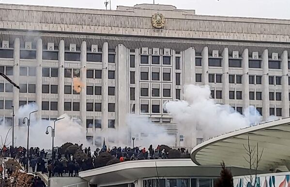 Manifestantes perto de prédio administrativo durante protestos contra a subida do preço de gás de petróleo liquefeito pelas autoridades cazaques, em Almaty, Cazaquistão, 5 de janeiro de 2022 - Sputnik Brasil