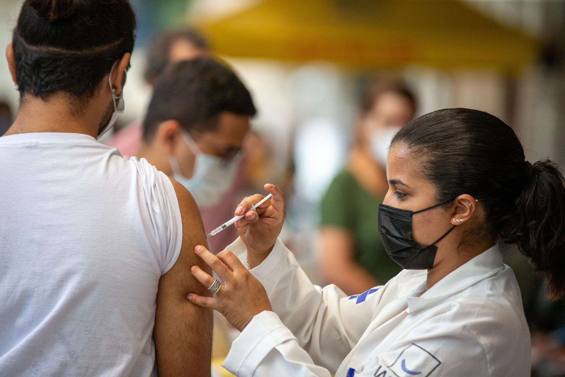 Em São Paulo, uma agente de saúde aplica uma dose de vacina contra a COVID-19 em um cidadão, em 16 de novembro de 2021 - Sputnik Brasil, 1920, 18.04.2022