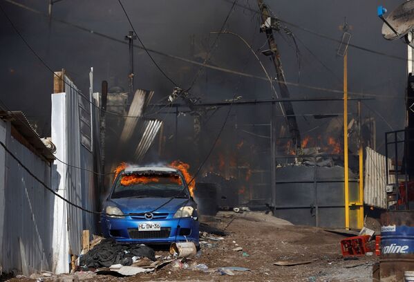 Carro queimando durante incêndio no bairro de baixa renda de Laguna Verde, Iquique, Chile, 10 de janeiro de 2022 - Sputnik Brasil