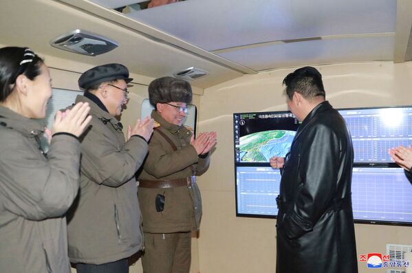 Líder norte-coreano, Kim Jong-un conversa com oficiais durante o que a mídia relata ser um teste demíssil hipersônico em um local desconhecido na Coreia do Norte, 11 de janeiro de 2022. - Sputnik Brasil
