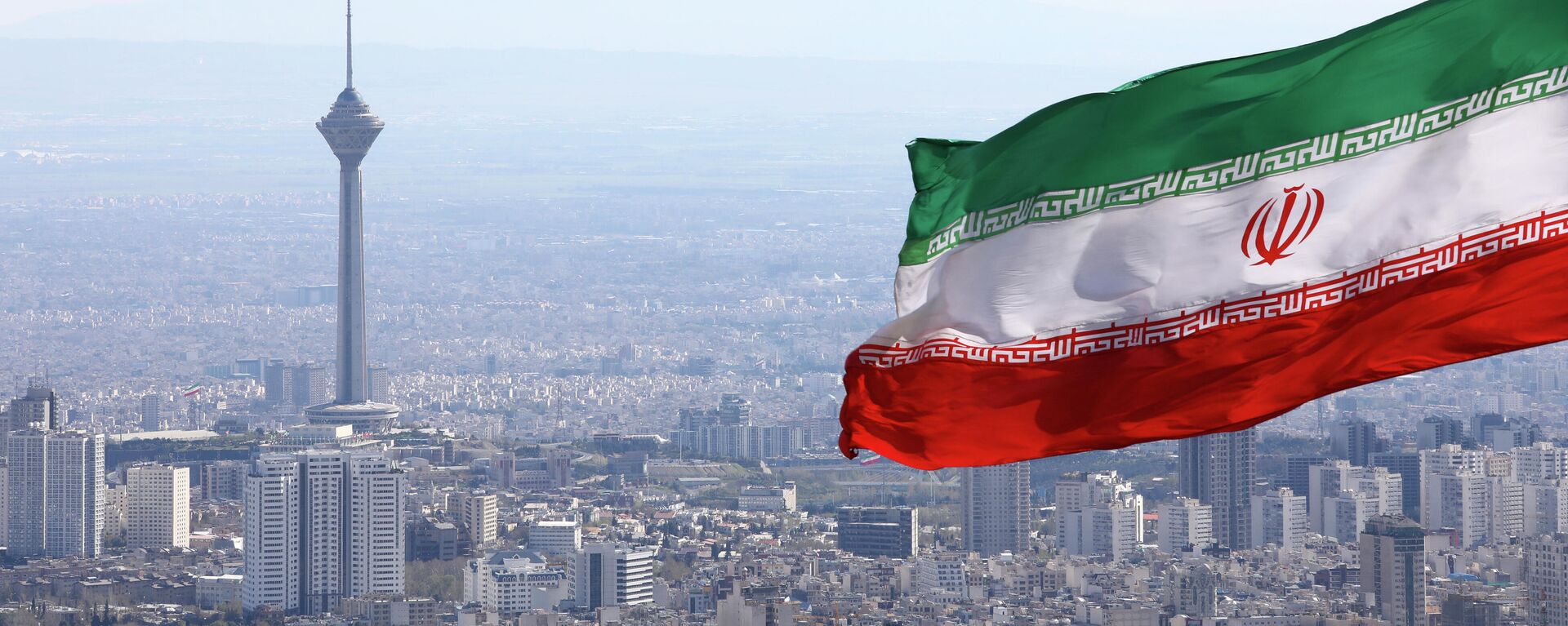A bandeira nacional do Irã acena como a torre de telecomunicações Milad e a bandeira nacional do buildinIran acena quando os togs de telecomunicações Milad são vistos em Teerã, Irã, terça-feira, 31 de março de 2020 - Sputnik Brasil, 1920, 12.04.2024