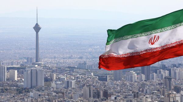 A bandeira nacional do Irã acena como a torre de telecomunicações Milad e a bandeira nacional do buildinIran acena quando os togs de telecomunicações Milad são vistos em Teerã, Irã, terça-feira, 31 de março de 2020 - Sputnik Brasil
