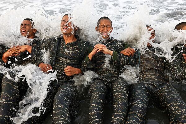 Os recrutas da ARP da Marinha de Taiwan lutam contra as ondas enquanto completam exercícios de treinamento durante a última semana de um programa de dez semanas para se tornarem membros da unidade de elite, na base naval de Zuoying, Kaohsiung, sul de Taiwan, 18 de dezembro de 2021. - Sputnik Brasil