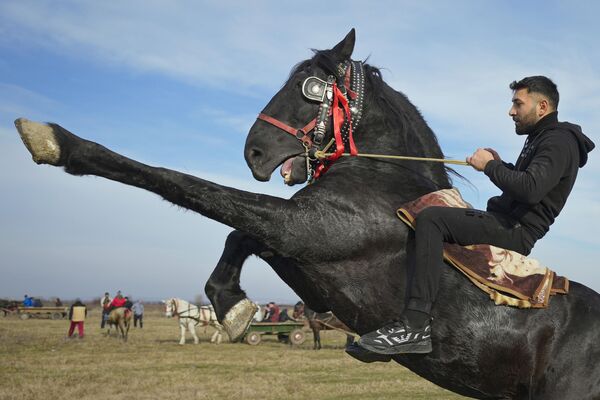 Homem demonstra habilidades de equitação durante as celebrações da Epifania no povoado de Pietrosani, na Roménia. - Sputnik Brasil