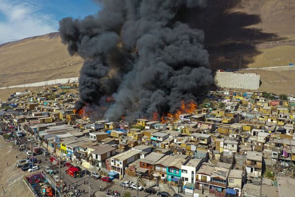 Casas são engolidas por chamas durante um incêndio em um bairro na cidade de Iquique, no Chile. - Sputnik Brasil