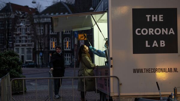 Em Amsterdã, nos Países Baixos, uma mulher faz teste gratuito de COVID-19 em uma unidade de testagem, em 30 de dezembro de 2021 - Sputnik Brasil