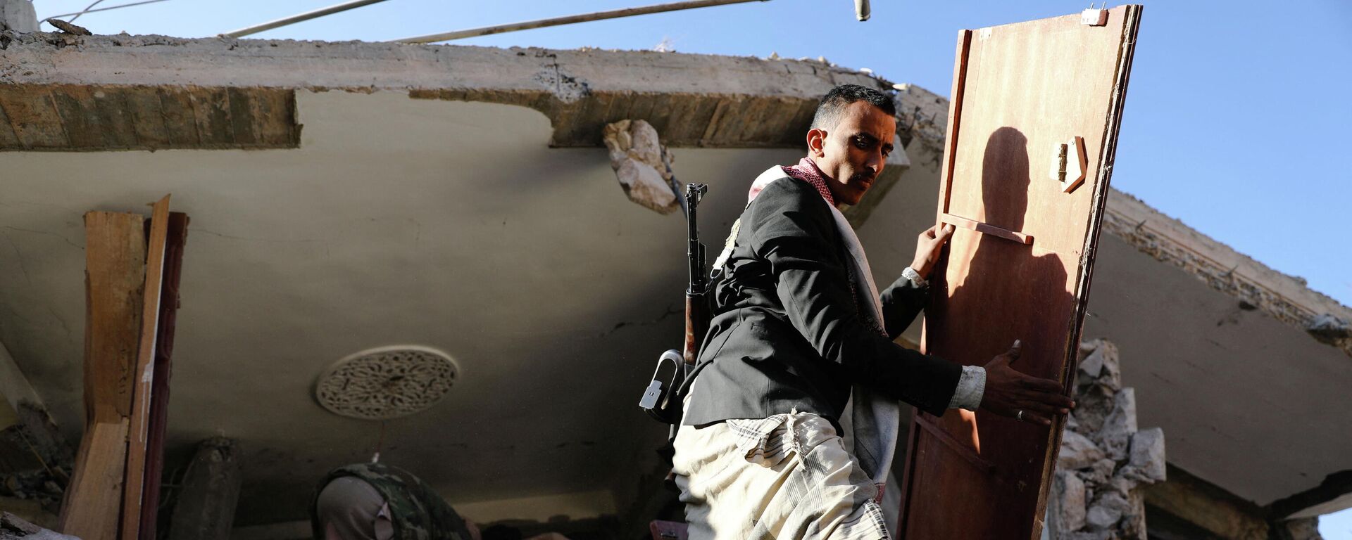 Em Saana, no Iêmen, cidadãos manipulam os destroços de um telhado de uma casa demolida por bombardeios de forças sauditas, em 18 de janeiro de 2022 - Sputnik Brasil, 1920, 18.01.2022