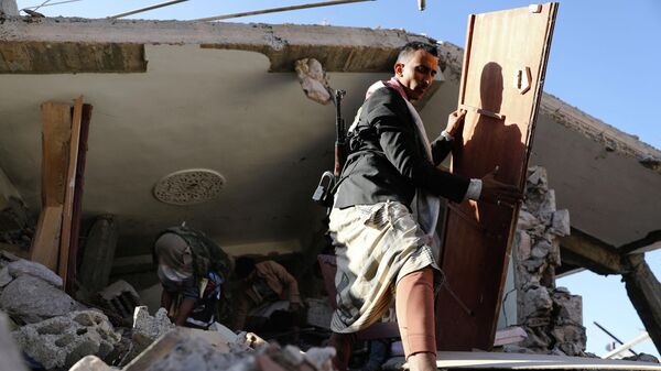 Em Saana, no Iêmen, cidadãos manipulam os destroços de um telhado de uma casa demolida por bombardeios de forças sauditas, em 18 de janeiro de 2022 - Sputnik Brasil