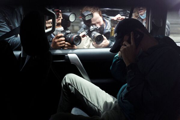 Fotógrafos tiram fotos de um homem não identificado saindo em um carro do estacionamento perto do escritório da equipe de advogados do tenista sérvio Novak Djokovic, sob escolta policial, em Melbourne, Austrália. - Sputnik Brasil