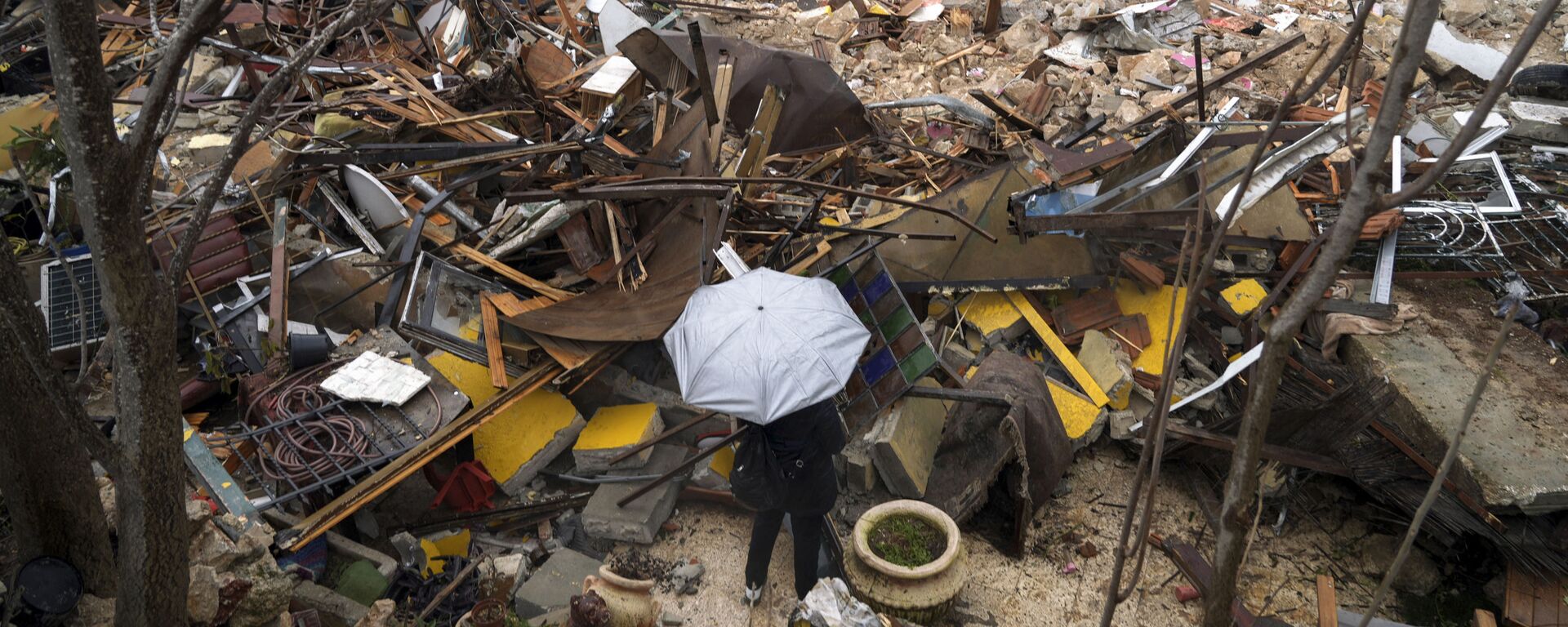 Mulher olha para as ruínas de uma casa palestina demolida pelo município de Jerusalém, no bairro de Sheikh Jarrah, em Jerusalém Oriental 
 - Sputnik Brasil, 1920, 14.12.2022