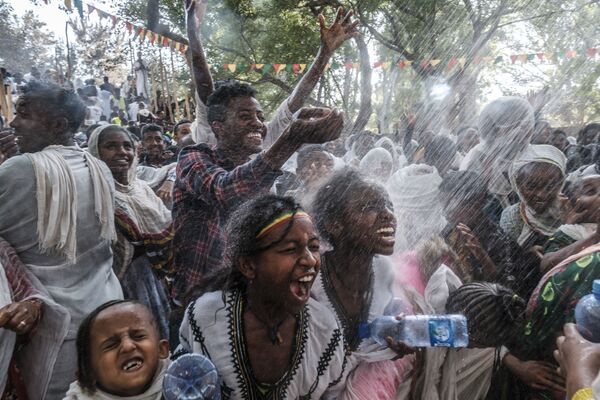 Cristãos ortodoxos etíopes são aspergidos com água durante a celebração de Timkat, a Epifania etíope, na cidade de Gondar, Etiópia. - Sputnik Brasil