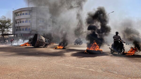 Motociclistas andam através de barricadas em chamas nas ruas centrais de Ouagadougou, cpaital de Burkina Faso, em meio aos protestos contra o presidente do país, 23 de janeiro de 2022 - Sputnik Brasil