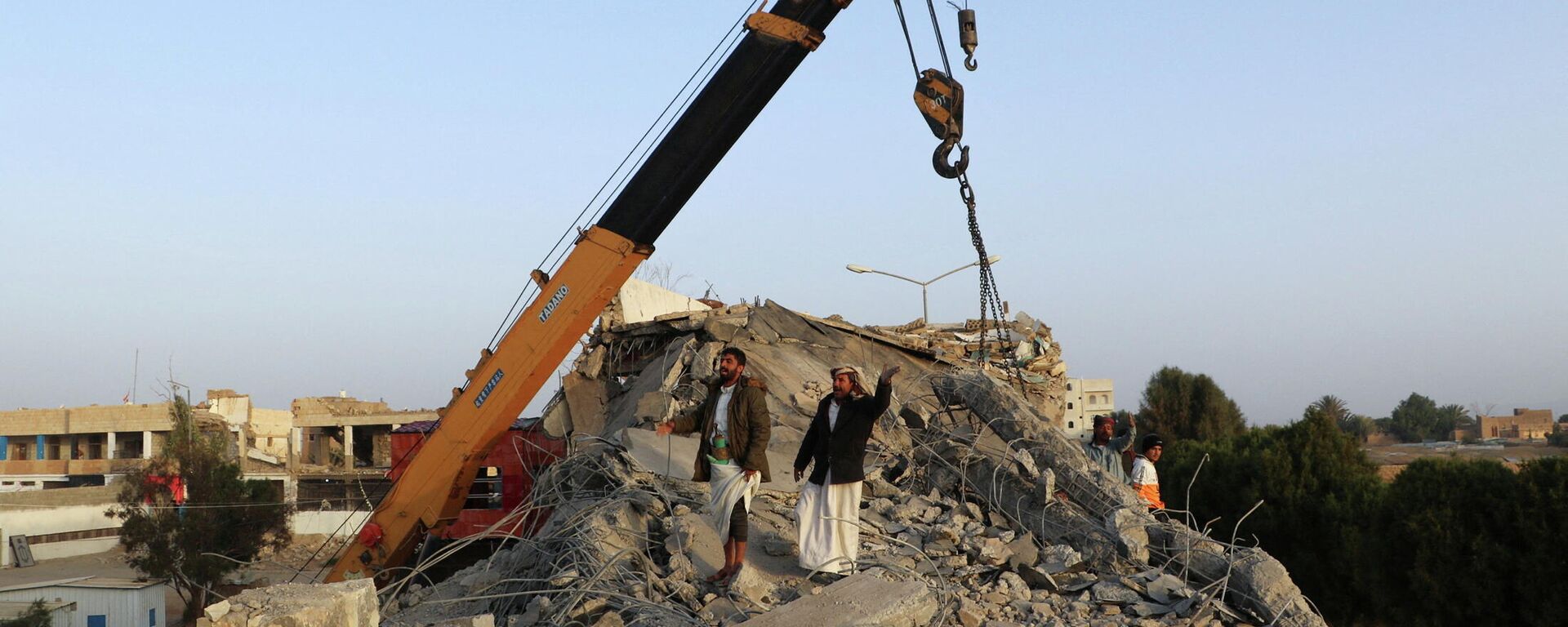 Socorristas usam guindaste para remover teto de concreto de um centro de detenção atingido por ataques aéreos em Saada, Iêmen, 21 de janeiro de 2022 - Sputnik Brasil, 1920, 24.01.2022