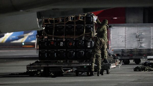 Membros do serviço ucraniano descarregam carregamento de ajuda militar entregue como parte da assistência de segurança dos Estados Unidos à Ucrânia, no Aeroporto Internacional de Boryspil, Kiev, 25 de janeiro de 2022 - Sputnik Brasil