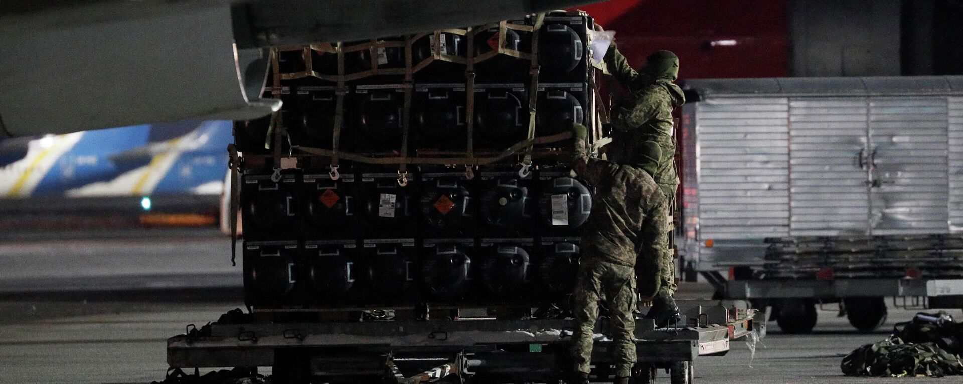 Membros do serviço ucraniano descarregam carregamento de ajuda militar entregue como parte da assistência de segurança dos Estados Unidos à Ucrânia, no Aeroporto Internacional de Boryspil, Kiev, 25 de janeiro de 2022 - Sputnik Brasil, 1920, 25.01.2022