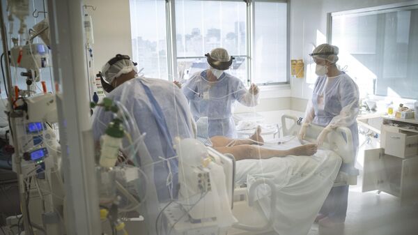 Em Porto Alegre, médicos e enfermeiros atendem um paciente com COVID-19 em uma UTI do Hospital das Clínicas, em 12 de março de 2021 - Sputnik Brasil