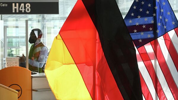 Em Munique, funcionários de uma companhia aérea trabalham em um aeroporto próximo de bandeiras da Alemanha e Estados Unidos, em 8 de novembro de 2021 - Sputnik Brasil