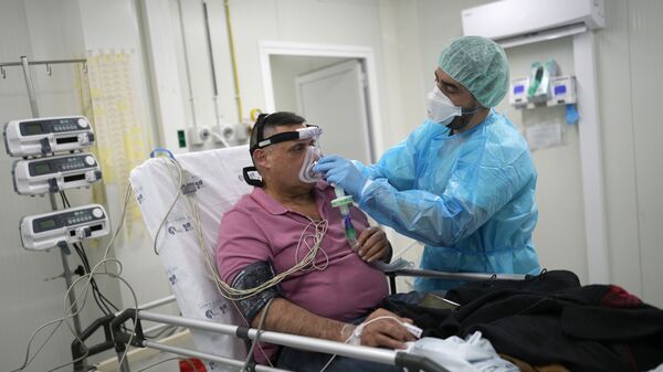 Enfermeiro colocando máscara de oxigênio a um paciente no Hospital de Santa Maria, 21 de janeiro de 2021 - Sputnik Brasil