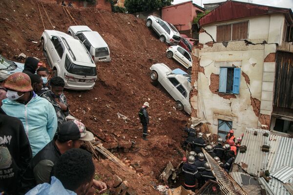 Bombeiros vasculham escombros após chuva ter provocado o desabamento de um parque de estacionamento sobre casas de Antananarivo, Madagáscar, 24 de janeiro de 2022 - Sputnik Brasil