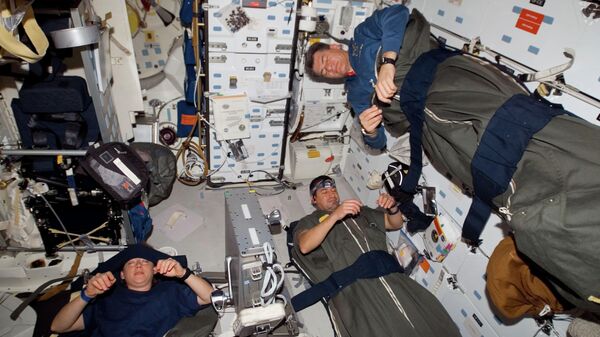 Astronautas dormindo dentro da espaçonave Discovery durante missão em 2007 - Sputnik Brasil