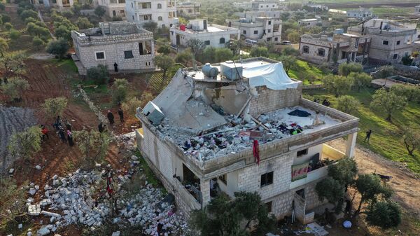 Pessoas observam casa destruída após operação militar americana na província síria de Idlib, 3 de fevereiro de 2022 - Sputnik Brasil