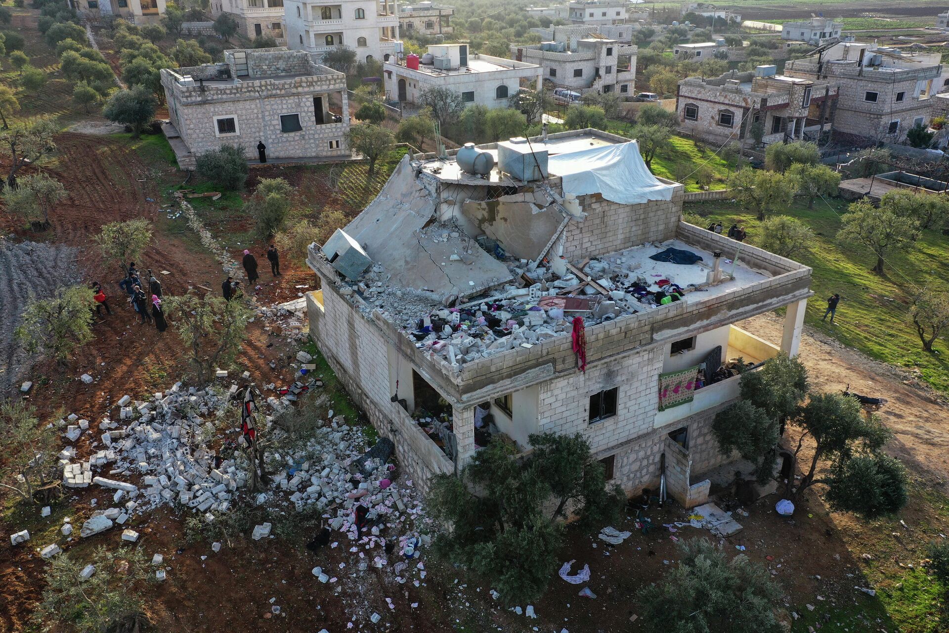 Pessoas observam casa destruída após operação militar americana na província síria de Idlib, 3 de fevereiro de 2022 - Sputnik Brasil, 1920, 04.02.2022