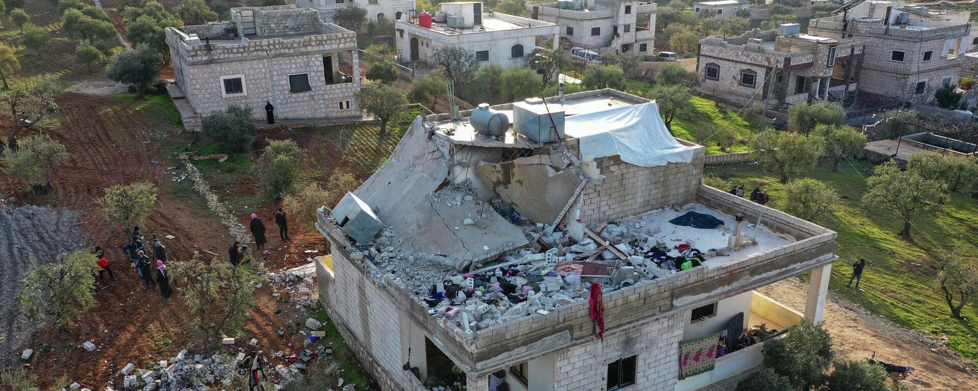 Pessoas observam casa destruída após operação militar americana na província síria de Idlib, 3 de fevereiro de 2022 - Sputnik Brasil, 1920, 03.07.2023