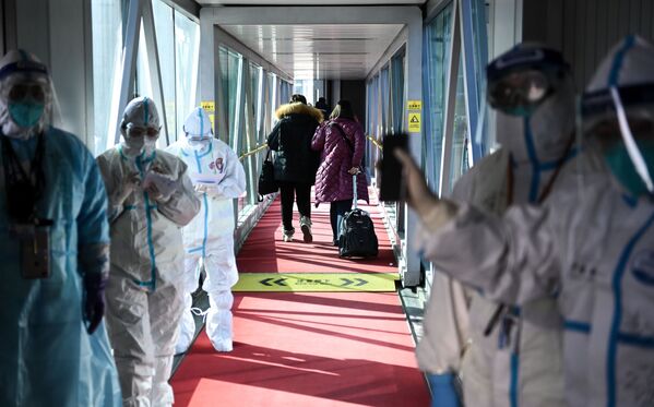 Funcionários de saúde em trajes de proteção no aeroporto de Pequim. - Sputnik Brasil