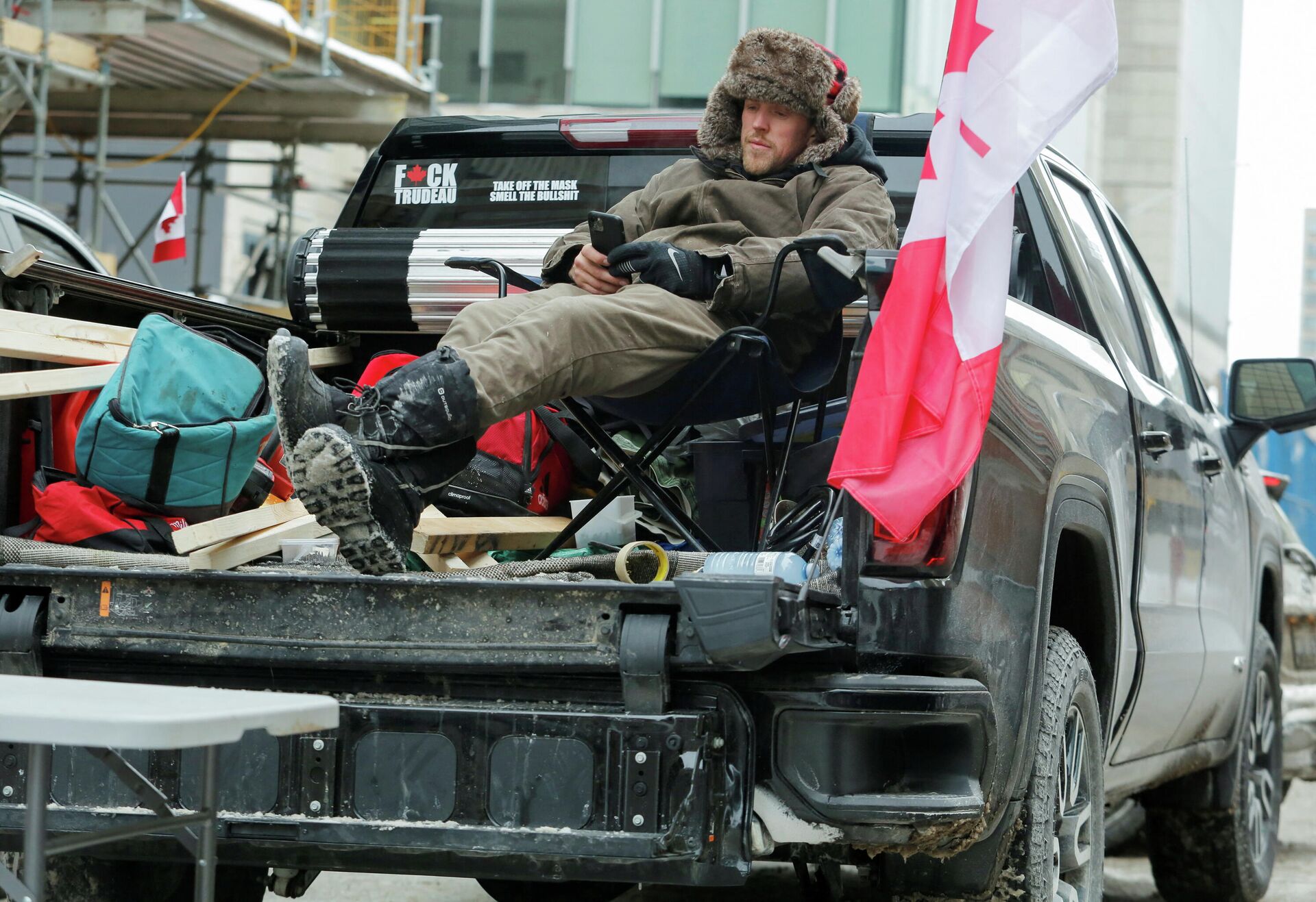Um homem relaxa em sua caminhonete enquanto caminhoneiros e apoiadores continuam protestando contra os mandatos da vacina COVID-19 em Ottawa, Canadá, 6 de fevereiro de 2022 - Sputnik Brasil, 1920, 09.02.2022
