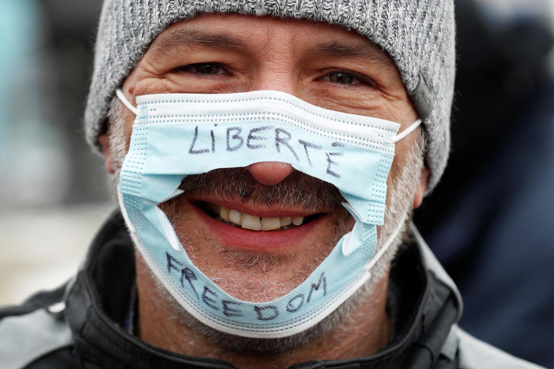 Homem usa uma máscara cirúrgica que foi cortada com as palavras Liberdade em inglês e francês, apoiando o protesto contra vacinas dos caminhoneiros, em Ottawa, Ontário, Canadá, 6 de fevereiro de 2022. - Sputnik Brasil, 1920, 07.02.2022