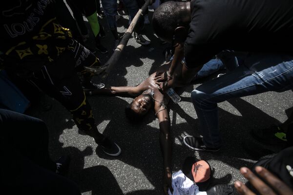 Manifestante simula a morte violenta de Moïse Kabagambe, assassinado no início desta semana no Rio de Janeiro. - Sputnik Brasil