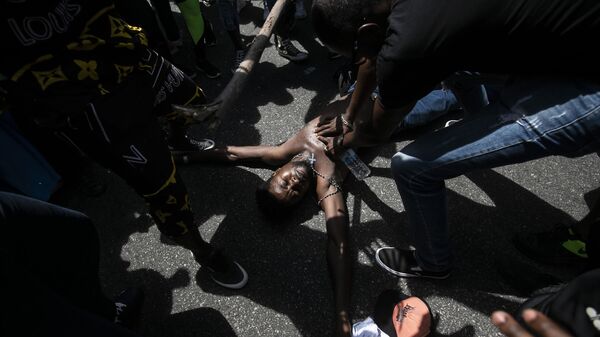 Manifestante simula a morte violenta de Moïse Kabagambe, assassinado no início desta semana no Rio de Janeiro - Sputnik Brasil