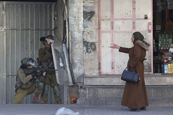 Mulher faz um gesto às forças de segurança israelenses na cidade de Hebron. - Sputnik Brasil