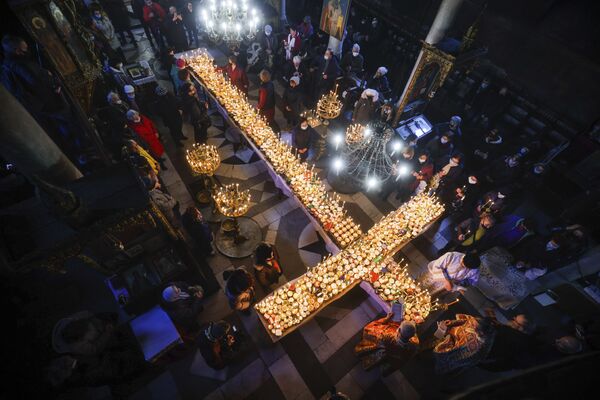 Centenas de jarros com mel e velas acesas em forma de cruz durante a missa de consagração do mel, na Igreja da Apresentação da Virgem Maria em Blagoevgrad, Bulgária. - Sputnik Brasil